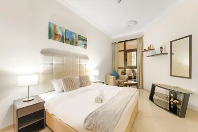 a bedroom with a large bed and a mirror at Dubai 1BR Balcony Views Near Miracle Garden in Dubai