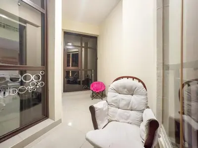 a white chair in a room with a pink chair at Dubai 1BR Balcony Views Near Miracle Garden in Dubai