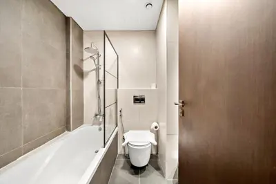 a bathroom with a toilet and a bath tub at FIRST CLASS 1BR Living Garden Luxury and Comfort in Dubai