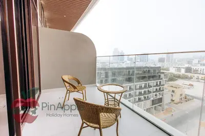 two chairs and a table on a balcony with a view at Beautiful Brand New Studio in Dubai