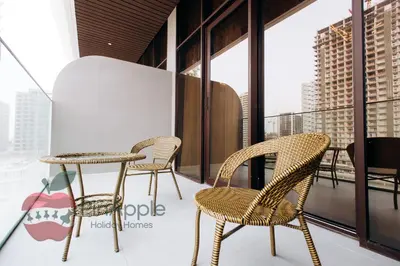 a table and chairs on a balcony with windows at Beautiful Brand New Studio in Dubai