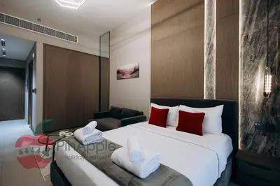 a hotel room with a large bed and a chair at Beautiful Brand New Studio in Dubai