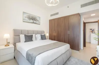 a bedroom with a large bed and a wooden cabinet at Vogue JVC Jeewar Tower near Circle Mall, One Bedroom Apartment with Balcony and City View, Access to all Amenities in Dubai