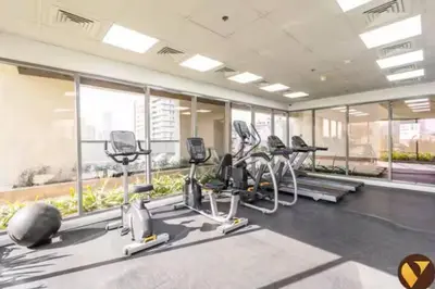 a gym with treadmills and ellipticals in a building at Vogue JVC Jeewar Tower near Circle Mall, One Bedroom Apartment with Balcony and City View, Access to all Amenities in Dubai