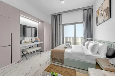 a bedroom with a bed and a desk and a television at New Studio in Meydan I MAG 890 in Dubai