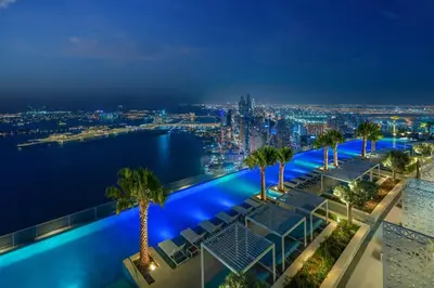 a pool on the roof of a building with palm trees at Luxury 1BR Sea View Apt Address JBR Dubai in Dubai