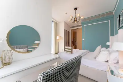 a bedroom with a bed with a mirror and a chair at Luxury 1BR Sea View Apt Address JBR Dubai in Dubai