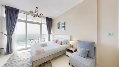 a bedroom with a bed and a chair and a window at Carson A - High Rise Cosy Studio with City Views in Dubai