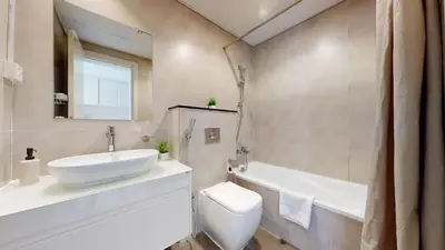 a bathroom with a sink and a toilet and a tub at Carson A - High Rise Cosy Studio with City Views in Dubai