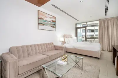 a living room with a couch and a bed at Modern Studio in the Heart of Sports City in Dubai