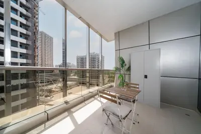a balcony with a table and chairs in a building at Modern Studio in the Heart of Sports City in Dubai
