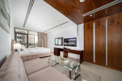 a living room with a couch and a bed at Modern Studio in the Heart of Sports City in Dubai