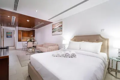a bedroom with a large bed and a living room at Modern Studio in the Heart of Sports City in Dubai