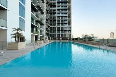 a large blue swimming pool in front of a building at Luxury Stay in JVC in Dubai