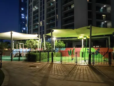a fence in a park at night with buildings at Modern 2BR Apartment with Stunning City Views in Dubai