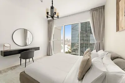 a bedroom with a large white bed and a mirror at Sea View 2BR Apartment With Private Beach in Dubai