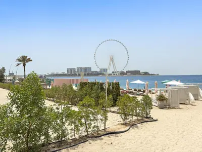 a beach with a ferris wheel in the background at Sea View 2BR Apartment With Private Beach in Dubai