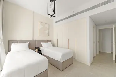 two beds in a room with white walls at Sea View 2BR Apartment With Private Beach in Dubai