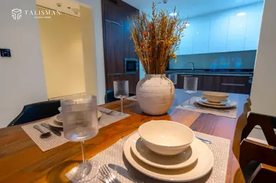 a table with plates and a vase on top of it at Elegant 1 BR Apartment in J One Tower in Dubai