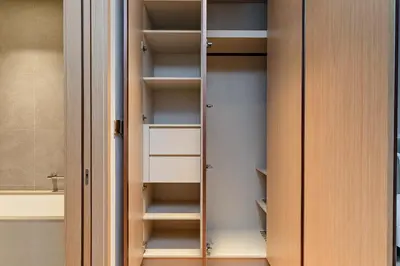a walk in closet with wooden doors and shelves at Vida Dubai Mall Connected 2BR in Sabkhah