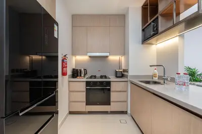a kitchen with wooden cabinets and a stove top oven at Vida Dubai Mall Connected 2BR in Sabkhah