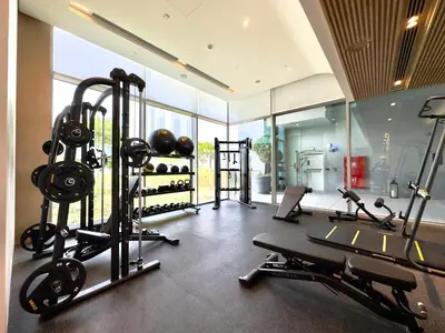 a gym with several treadmills and weights in a room at Vida Dubai Mall Connected 2BR in Sabkhah
