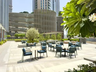 a patio with tables and chairs and buildings at Vida Dubai Mall Connected 2BR in Sabkhah