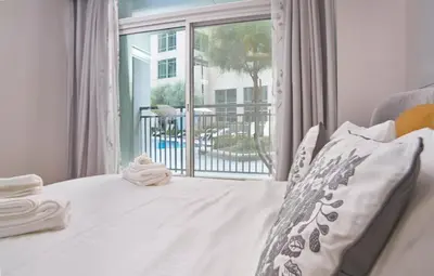 a bedroom with a bed and a large window at Vista Downtown Poolside 1BR Walk to Burj Khalifa in Dubai