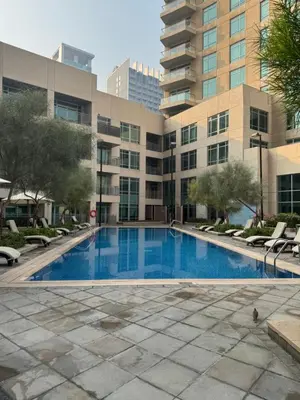 an empty swimming pool in front of a building at Vista Downtown Poolside 1BR Walk to Burj Khalifa in Dubai