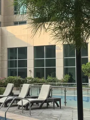 a row of lounge chairs in front of a building at Vista Downtown Poolside 1BR Walk to Burj Khalifa in Dubai