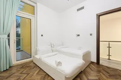 a white room with two beds and a mirror at FIRST CLASS VILLA Tranquility Meets Luxury in Dubai