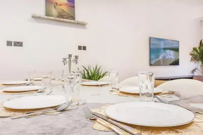 a table with white plates and silverware on it at FIRST CLASS VILLA Tranquility Meets Luxury in Dubai