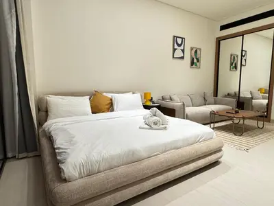 a bedroom with a large bed and a living room at DVR Studio Apartment with private jaccuzi in Trillionaire by Binghatti Business Bay in Dubai