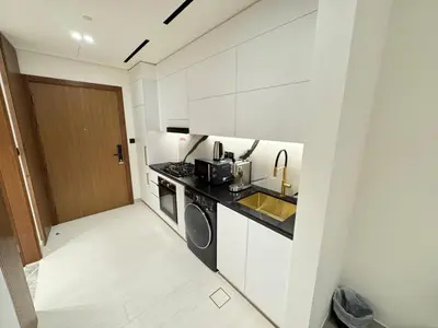 a white kitchen with a sink and a stove at DVR Studio Apartment with private jaccuzi in Trillionaire by Binghatti Business Bay in Dubai