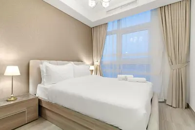 a bedroom with a white bed and a window at FIRST CLASS VILLA Spacious for Family Getaways in Dubai