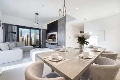 a living room with a dining table and chairs at Restay Homes at Act Towers by Emaar - Pool access with Burj View included - Luxury Apartments in Downtown in Dubai