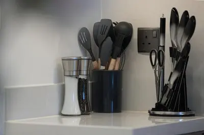 a container filled with utensils sitting on a counter at Restay Homes at Act Towers by Emaar - Pool access with Burj View included - Luxury Apartments in Downtown in Dubai
