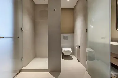 a bathroom with a toilet and a glass door at Vida Dubai Mall Connected 1BR in Dubai