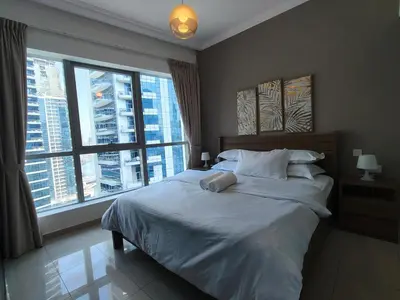 a bedroom with a large bed and two windows at Bay View in Marina Bay in Dubai