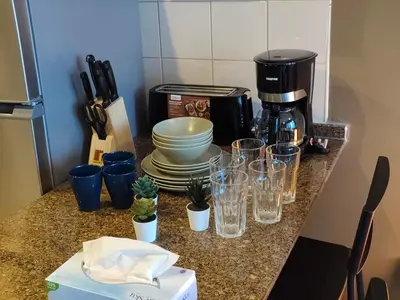 a counter with glasses and a coffee maker on it at Bay View in Marina Bay in Dubai