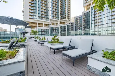 a balcony with chairs and tables on a building at Stylish 1BR with City and Partial Burj View by BMS in Dubai