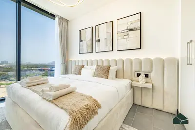 a bedroom with a large bed with a large window at Stylish 1BR with City and Partial Burj View by BMS in Dubai