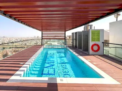 a swimming pool on the roof of a building at Studio with Community Views, Easy Access to Bus Stop, Parks, and Circle Mall, Empire Residence, JVC by Deluxe Holiday Homes in Dubai