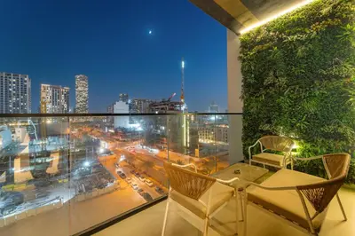a balcony with a table and chairs and a view of a city at Bright & Cozy 1BR Apartment with Balcony in JVC in Dubai