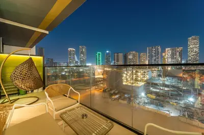 a balcony with a view of a city at night at Bright & Cozy 1BR Apartment with Balcony in JVC in Dubai
