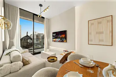 a living room with a couch and a table at Bright & Cozy 1BR Apartment with Balcony in JVC in Dubai