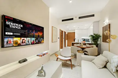 a living room with a couch and a tv at Bright & Cozy 1BR Apartment with Balcony in JVC in Dubai