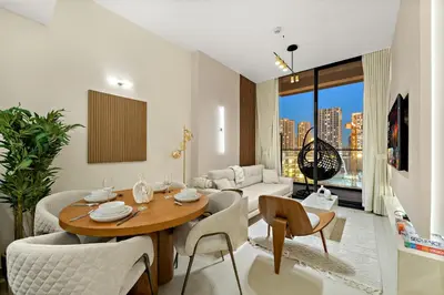 a living room with a table and chairs and a couch at Bright & Cozy 1BR Apartment with Balcony in JVC in Dubai