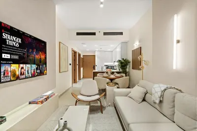 a living room with a couch and a table at Bright & Cozy 1BR Apartment with Balcony in JVC in Dubai