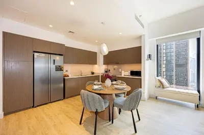 a kitchen with a table and chairs and a refrigerator at Brand new 2BR in Downtown 5 min walk to Burj Khalifa in Dubai